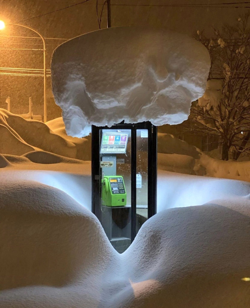 A Japanese telephone booth covered in snow